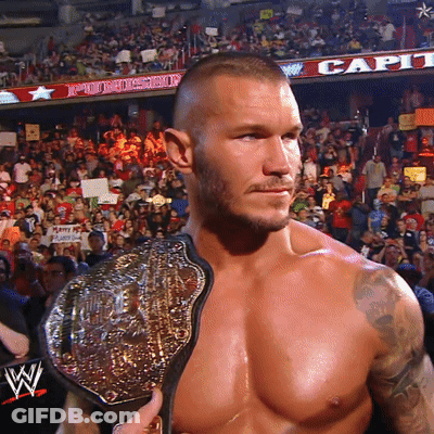 A Shirtless Wrestler Holds A Wrestling Belt In Front Of A Crowd GIF