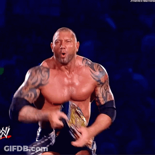 A Shirtless Wrestler Holds A Wrestling Championship While Wearing A Green Belt That Says ' Smackdown ' GIF
