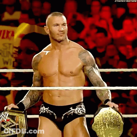 A Shirtless Wrestler In A Wrestling Ring Holding A WWE Championship Belt GIF