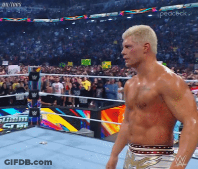 A Shirtless Wrestler In A Wrestling Ring With A Crowd Behind Him GIF