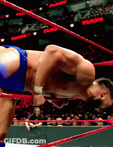 A Shirtless Wrestler In A Wrestling Ring With A Crowd Watching And A Sign That Says Rams GIF