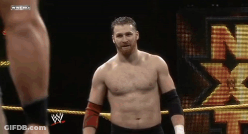 A Shirtless Wrestler In A Wrestling Ring With A N On The Back GIF
