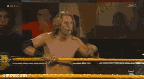A Shirtless Wrestler In A Wrestling Ring With The Hashtag # 205Live On The Bottom GIF