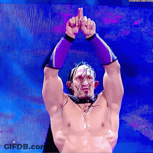 A Shirtless Wrestler Is Giving The Middle Finger While Wearing Purple Gloves GIF