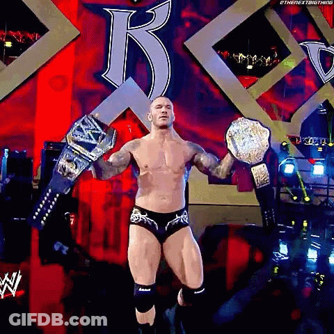 A Shirtless Wrestler Is Holding A Wrestling Championship Belt GIF