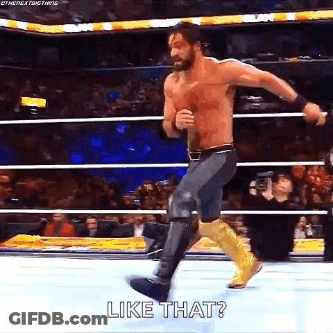 A Shirtless Wrestler Is Jumping In The Air In A Wrestling Ring While Saying `` Like That '' . GIF