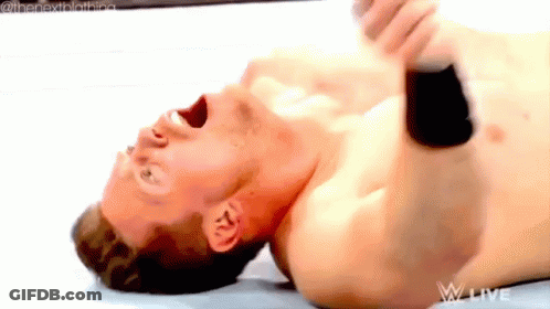 A Shirtless Wrestler Is Laying On His Back With His Mouth Open GIF