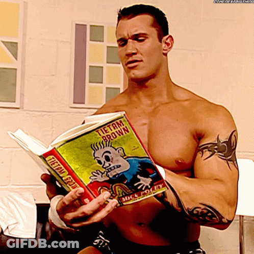 A Shirtless Wrestler Is Reading A Book Titled Tietam Brown GIF