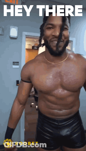 A Shirtless Wrestler Is Standing In Front Of A Door With The Words Hey There Above Him GIF