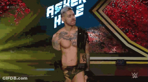 A Shirtless Wrestler Is Standing In Front Of A Sign That Says Ascension GIF