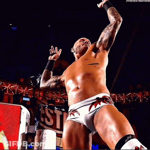 A Shirtless Wrestler Is Standing In Front Of A Sign That Says ' Ethenextbigthing ' GIF
