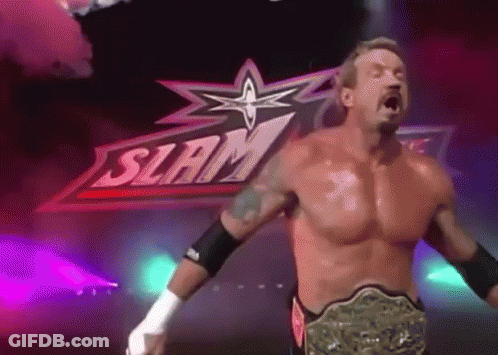 A Shirtless Wrestler Is Standing In Front Of A Sign That Says Slam GIF