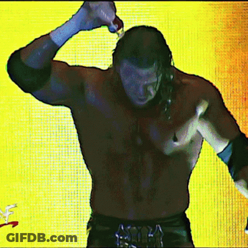 A Shirtless Wrestler Is Standing In Front Of A Yellow Background With A Wwe Logo In The Corner GIF