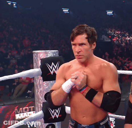 A Shirtless Wrestler Stands In A Ring With A Sign That Says Mot Mach On It GIF