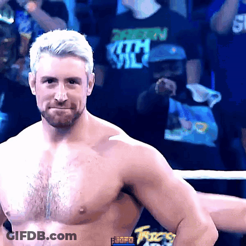 A Shirtless Wrestler Stands In Front Of A Crowd Wearing A Shirt That Says ' Shawn Michaels ' On It GIF