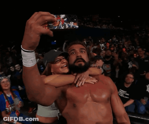 A Shirtless Wrestler Takes A Selfie With A Fan In The Crowd GIF