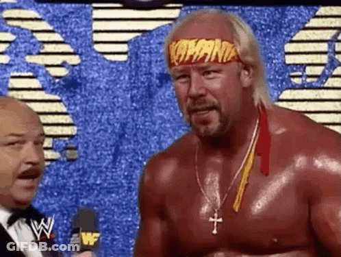 A Shirtless Wrestler Wearing A Headband That Says Hulk Hogan Is Talking To A Microphone . GIF