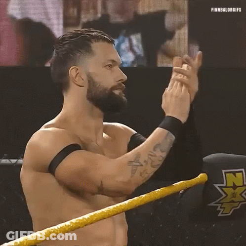 A Shirtless Wrestler With A Beard Is Standing In A Wrestling Ring Clapping His Hands . GIF