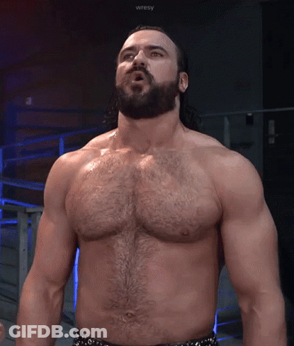 A Shirtless Wrestler With A Beard Is Standing In Front Of A Sign That Says Wresty GIF