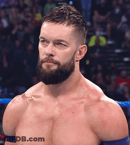 A Shirtless Wrestler With A Beard Stands In A Ring GIF