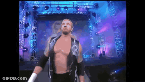 A Shirtless Wrestler With A Lightning Bolt On His Chest Is Walking Through A Tunnel GIF