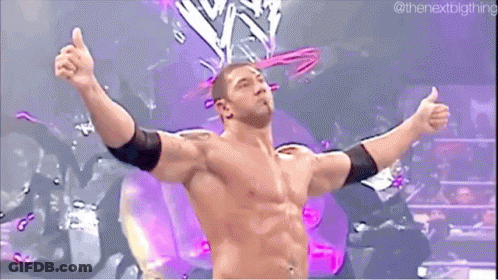 A Shirtless Wrestler With His Arms Outstretched In Front Of A Purple Background . GIF