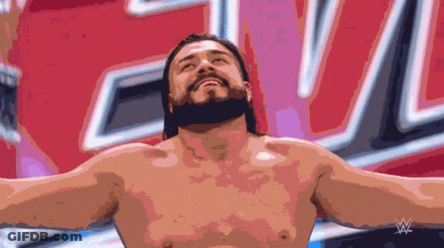 A Shirtless Wrestler With His Arms Outstretched In Front Of A Sign That Says W GIF