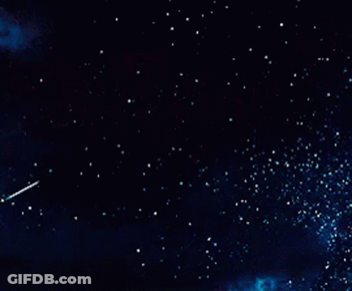A Shooting Star Flies Through A Dark Night Sky GIF