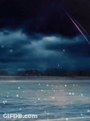 A Shooting Star Is Visible Over A Body Of Water At Night GIF
