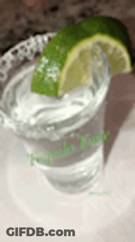 A Shot Glass Of Tequila With A Slice Of Lime On Top GIF