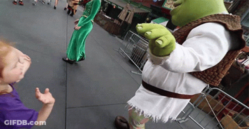 A Shrek Mascot Standing Next To A Little Girl In A Purple Shirt GIF