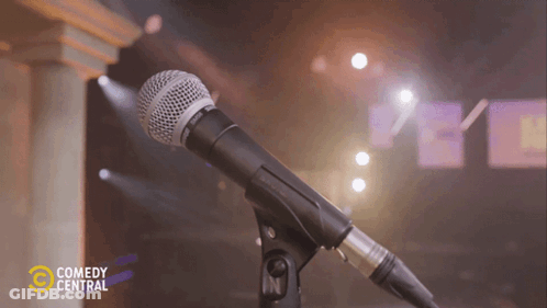 A Shure Microphone On A Stand With Comedy Central Written On The Bottom GIF