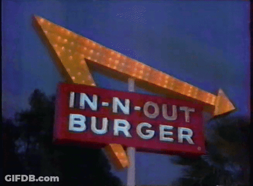 A Sign For An In-N-Out Burger Restaurant Is Lit Up At Night GIF