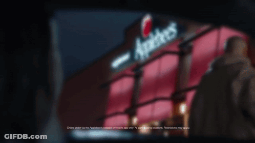 A Sign For Applebee 'S Is Lit Up In The Dark GIF