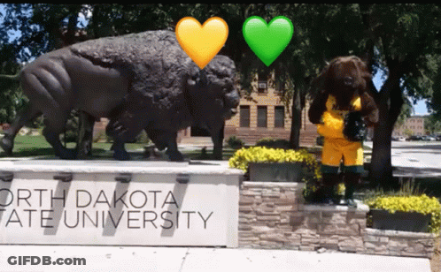 A Sign For North Dakota State University With A Statue In The Background GIF