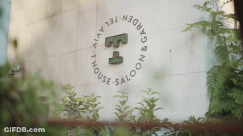 A Sign For The Garden Tel Aviv House Saloon Is Surrounded By Plants GIF