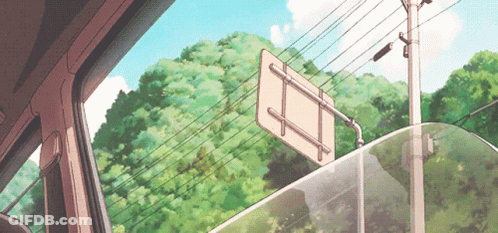A Sign Is Hanging From A Pole In Front Of A Forest GIF