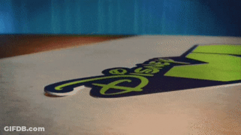A Sign That Says Disney On It Is Laying On The Ground GIF