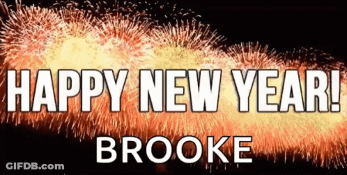 A Sign That Says Happy New Year Brooke In Front Of Fireworks GIF