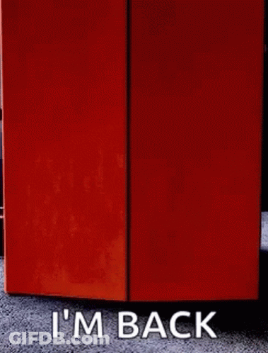 A Sign That Says I 'M Back Next To An Orange Box GIF