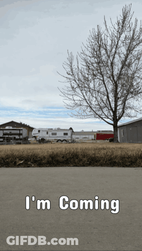A Sign That Says " I 'M Coming " With A Tree In The Background GIF