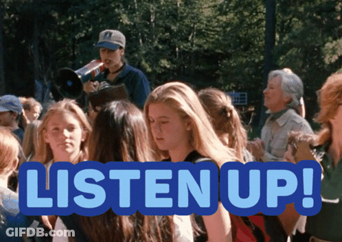 A Sign That Says Listen Up In Front Of A Crowd GIF