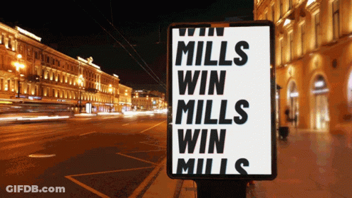 A Sign That Says " Mills Win Mills Win Mills " On It GIF