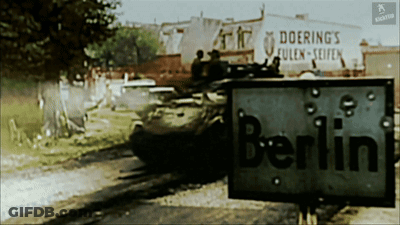 A Sign With Bullet Holes In It Says Berlin GIF