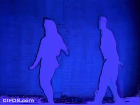 A Silhouette Of A Man And A Woman Dancing In Front Of A Blue Wall . GIF