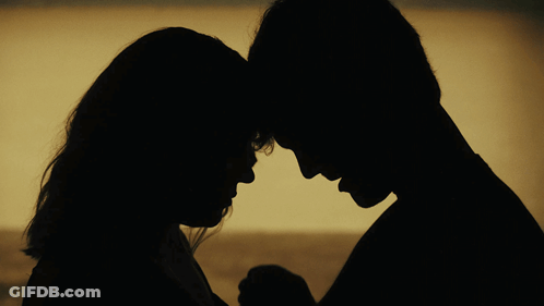 A Silhouette Of A Man And A Woman Holding Hands GIF