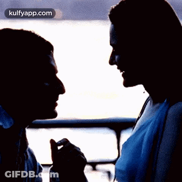 A Silhouette Of A Man And A Woman Looking At Each Other With A Kulfyapp.com Logo In The Corner GIF