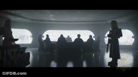 A Silhouette Of A Man Holding A Gun Standing In Front Of A Group Of People . GIF