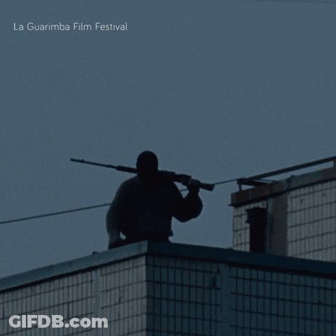 A Silhouette Of A Man Holding A Gun With La Guarimba Film Festival Written On The Bottom Right GIF