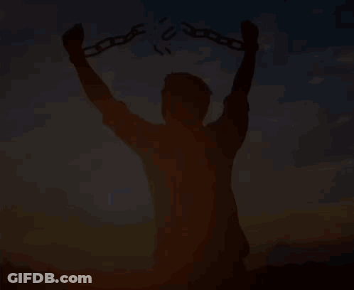A Silhouette Of A Man Holding Chains In His Hands At Sunset . GIF
